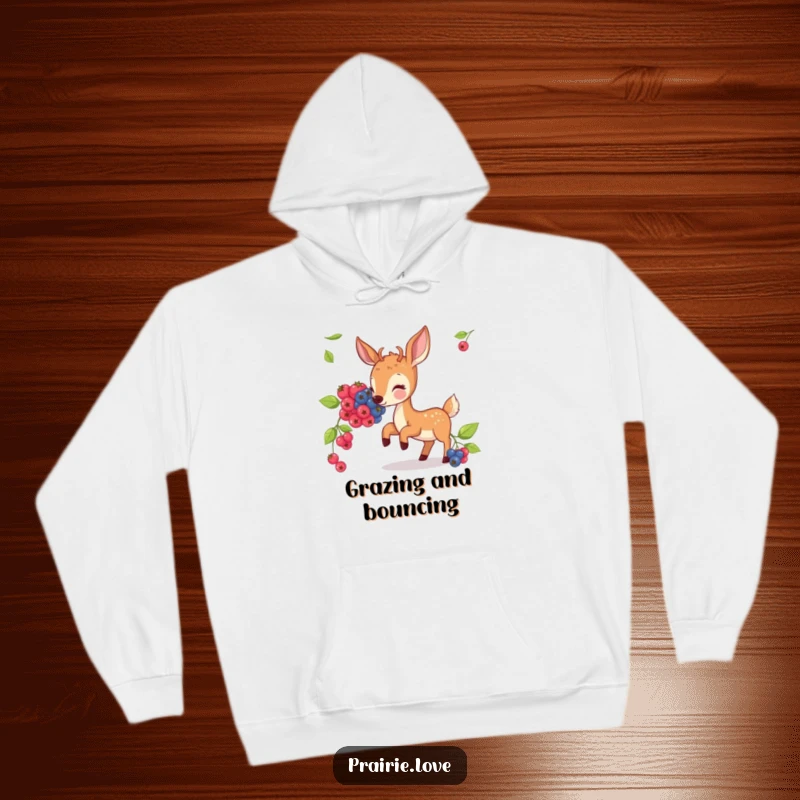 Funny hoodie showcasing a bouncing deer happily munching on illustrated berries, embodying a peaceful forest scene.
